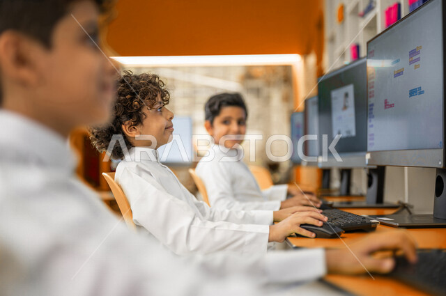 مجموعه من الطلاب العرب السعوديون الخليجيون في بيئه مدرسيه تعليميه متطوره, معمل الحاسوب, التعليم الإلكتروني المتطور, منصات تعليميه, التعليم الذكي, تعزيز العلوم والإبتكارات، المدارس المبتكره, جودة التعليم, مدارس أكاديميه في السعوديه