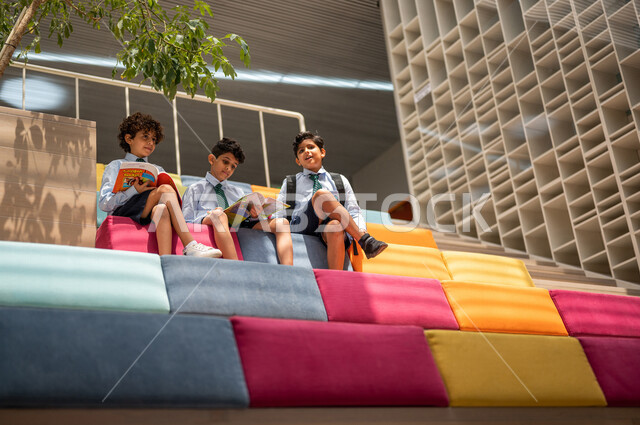 مجموعه من الطلاب العرب السعوديون الخليجيون يجلسون على الأدراج في بهو المدرسه, المذاكره والمراجعه, الإستعداد للإمتحانات, بيئه مدرسيه تعليميه متطوره, التعليم الذكي, عالم جديد من التعليم، المدارس المبتكره, جودة التعليم, مدارس أكاديميه في السعوديه