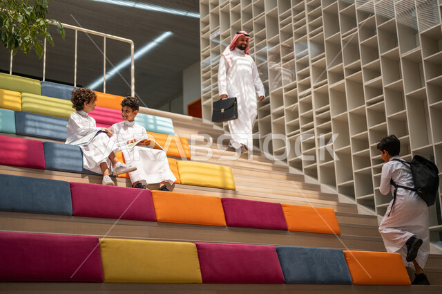 طالبان عربيان سعوديان خليجيان يجلسان على الأدراج في بهو المدرسه, المذاكره والمراجعه, الإستعداد للإمتحانات, بيئه مدرسيه تعليميه متطوره, التعليم الذكي, عالم جديد من التعليم، المدارس المبتكره, جودة التعليم, مدارس أكاديميه في المملكه العربيه السعوديه