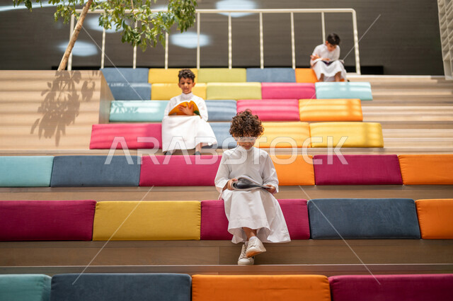 مجموعه من الطلاب العرب السعوديون الخليجيون يجلسون على الأدراج في بهو المدرسه, المذاكره والمراجعه, الإستعداد للإمتحانات, بيئه مدرسيه تعليميه متطوره, التعليم الذكي, عالم جديد من التعليم، المدارس المبتكره, جودة التعليم, مدارس أكاديميه في السعوديه