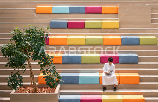 طالب عربي سعودي خليجي يجلس على الأدراج في بهو المدرسه, المذاكره والمراجعه, الإستعداد للإمتحانات, بيئه مدرسيه تعليميه متطوره, التعليم الذكي, عالم جديد من التعليم، المدارس المبتكره, جودة التعليم, مدارس أكاديميه في المملكه العربيه السعوديه