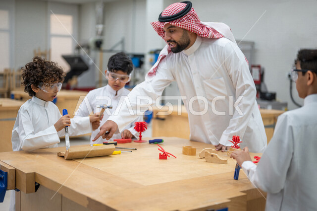 معلم عربي سعودي خليجي في بيئه مدرسيه تعليميه متطوره، متابعة مجموعة من الطلاب داخل الفصل, نظام التعليم المنتسوري, التعليم الذكي، عالم جديد من التعليم, تعزيز العلوم والإبتكارات, تنمية المهارات ، المدارس المبتكره, جودة التعليم, مدارس أكاديميه في السعوديه