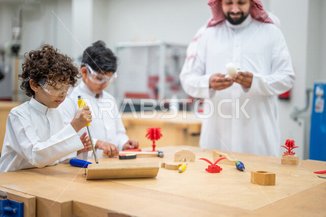 معلم عربي سعودي خليجي في بيئه مدرسيه تعليميه متطوره، متابعة مجموعة من الطلاب داخل الفصل, نظام التعليم المنتسوري, التعليم الذكي، عالم جديد من التعليم, تعزيز العلوم والإبتكارات, تنمية المهارات ، المدارس المبتكره, جودة التعليم, مدارس أكاديميه في السعوديه