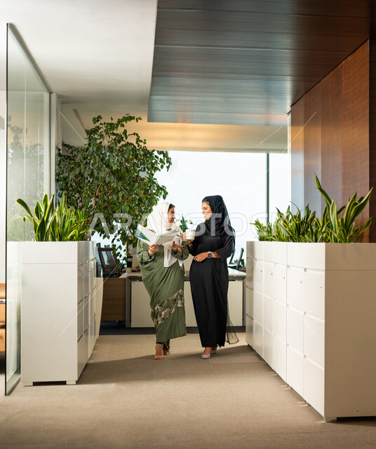 موظفتان عربيتان سعوديتان خليجيتان داخل مقر الشركة، ترتديان عبايات عصرية مميزة، أزياء محجبات، مهن و وظائف سعودية، شركة سعودية، سيدات أعمال، الحوارات والنقاشات، بيئة العمل، دردشة عمل، متابعة ومناقشة الأعمال