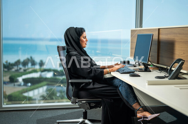 مرأة عربية خليجية سعودية، تستخدم جهاز الحاسوب المحمول لإنجاز المهام، جلسة عمل، إنجاز المشاريع والمهام، مهن ووظائف سعودية، متابعة الأعمال، عقد إجتماع عمل عبر الإنترنت، التسويق الإلكتروني، تصفح الإنترنت، شركة سعودية، العمل عن بعد