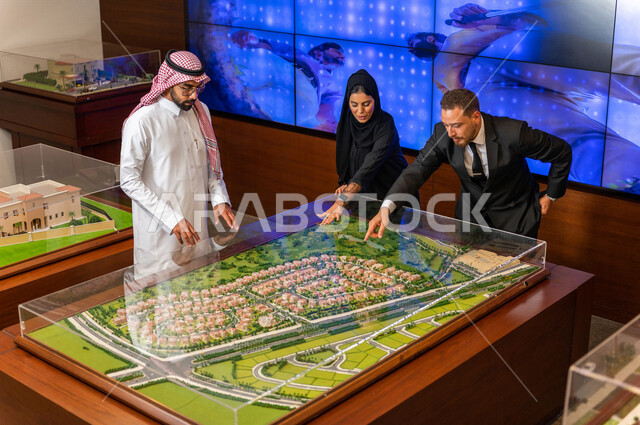 مجموعة من المصممين والمهندسين المعماريين المحترفين في غرفة الإجتماعات داخل مقر الشركة، نموذج بناء هندسي جديد لمشروع التخطيط العمراني، مهن ووظائف سعودية، شركة سعودية، الشراكة والتعاون، الحوارات والنقاشات، بيئة العمل، زملاء عمل