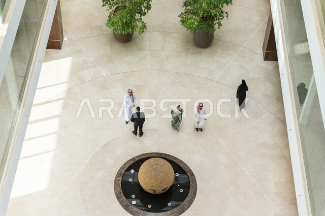 صورة من الأعلى لموظفين عرب سعوديين خليجيين داخل مقر الشركة ، تعارف وصداقات ، علاقات إجتماعية ، مهن ووظائف سعودية ، شركة سعودية ، فريق عمل سعودي ، الشراكة والتعاون ، الحوارات والنقاشات ، بيئة العمل ، زملاء عمل