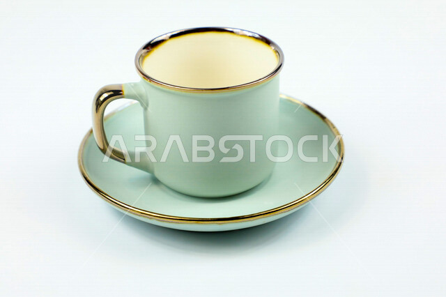 صورة مقربة لكوب تركوازي اللون، فنجان ازرق فارغ، طبق صغير، كوب زجاجي، خلفية بيضاء