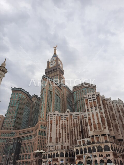 An aesthetic image from inside the Holy Mosque in Mecca, the royal clock tower building in the daytime, performing Hajj and Umrah, worship and getting closer to God, Islamic religious landmarks in the Kingdom of Saudi Arabia