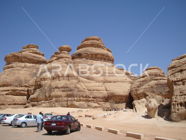 مجموعة من السياح في زيارة لمحافظة العلا بالمملكة العربية السعودية، التكوينات الصخرية الطبيعية في مدائن صالح، الطبيعة الصحراوية، الجبال والتشكيلات الصخرية في محافظة العلا، أماكن سياحية، معالم تاريخية أثرية قديمة