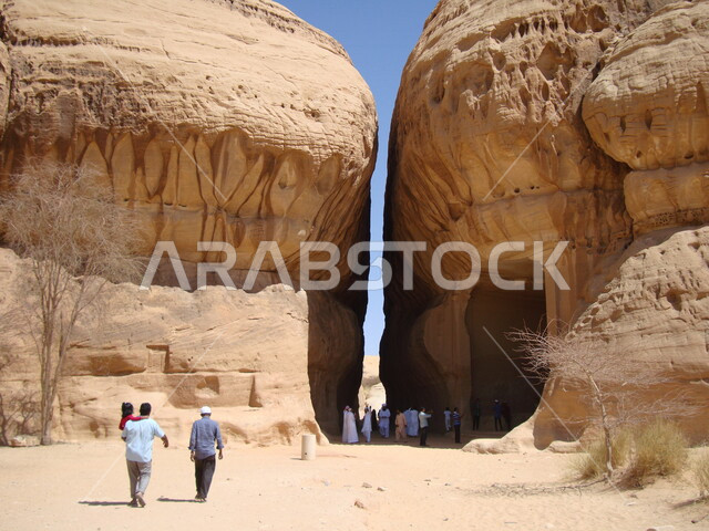 مجموعة من السياح في زيارة لمحافظة العلا بالمملكة العربية السعودية، التكوينات الصخرية الطبيعية في مدائن صالح، الطبيعة الصحراوية، الجبال والتشكيلات الصخرية في محافظة العلا، أماكن سياحية، معالم تاريخية أثرية قديمة