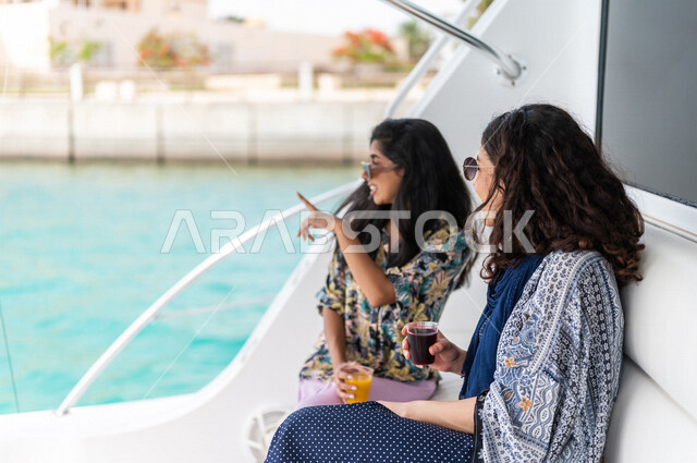 صديقتان عربيتان سعوديتان خليجيتان على متن يخت في البحر, الإستمتاع بالمشروبات البارده, أوقات سعيده مع الأصدقاء, متعة الإبحار في القوارب والسفن, جولات بحريه ممتعه على كورنيش جده, أنشطه ترفيهيه, رحلات بحريه في مارينا جده, عطله صيفيه, السياحه في السعوديه