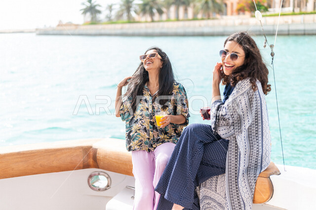 صديقتان عربيتان سعوديتان خليجيتان على متن يخت في البحر, الإستمتاع بالمشروبات البارده, أوقات سعيده مع الأصدقاء, متعة الإبحار في القوارب والسفن, جولات بحريه ممتعه على كورنيش جده, أنشطه ترفيهيه, رحلات بحريه في مارينا جده, عطله صيفيه, السياحه في السعوديه