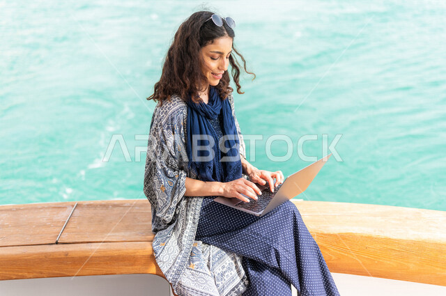 إمرأه عربيه سعوديه خليجيه على متن يخت, إستخدام جهاز الحاسوب المحمول, إدارة الأعمال عن بعد, التسوق الإلكتروني, التواصل الإجتماعي, متعة الإبحار في القوارب والسفن, جولات بحريه على كورنيش جده, رحلات بحريه في مارينا جده, عطله صيفيه, السياحه في السعوديه