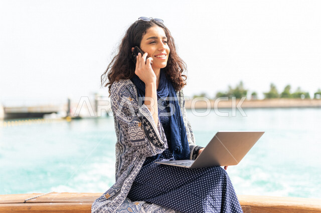 إمرأه عربيه سعوديه خليجيه على متن يخت, إجراء مكالمه هاتفيه عبر الهاتف المحمول, إستخدام جهاز الحاسوب المحمول, إدارة الأعمال عن بعد, التواصل الإجتماعي, الإبحار في القوارب والسفن, جولات بحريه على كورنيش جده, رحلات بحريه في مارينا جده, السياحه في السعوديه