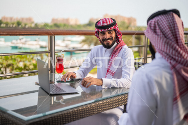 زملاء عمل عرب خليجيون سعوديون مجتمعون في مقهى احد الفنادق الخليجية، استخدام الحاسوب المحمول، حوار ونقاش عمل خارج الشركه، انجهاز مهام العمل، إدارة الأعمال عن بعد، توزيع مهام العمل بين الزملاء، قضاء أجمل الأوقات في أفضل الفنادق الخليجية، سياحة وفندقة