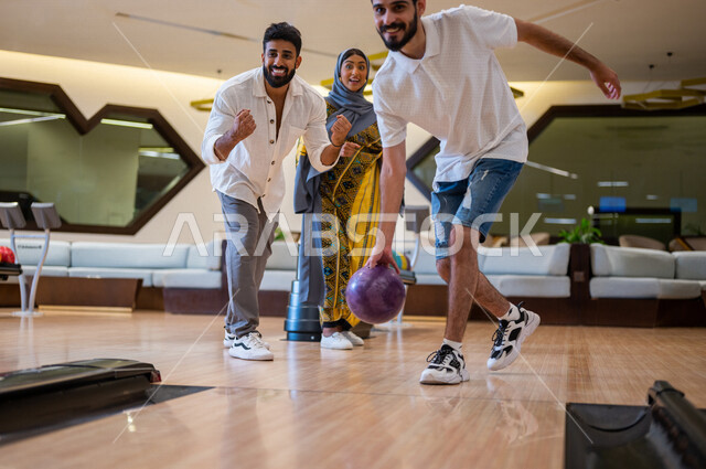 A group of Saudi Arabian Gulf friends practicing bowling, a bowling track, a young man preparing to throw a bowling ball, recreational sports activities, recreational bowling, youth activities and sports, competitions and challenges, a team of friends in 