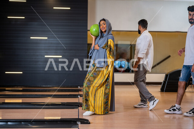 مجموعة من الاصدقاء العرب الخليجيون السعوديون يمارسون لعبه الولينج، مضمار البولينج، شابة تستعد لرمي كرة البولينج، انشطه ترفيهيه رياضية، كره البولينج الترفيهية، انشطه ورياضات شبابية، منافسات وتحديات، فريق من الاصدقاء في ملعب البولينج