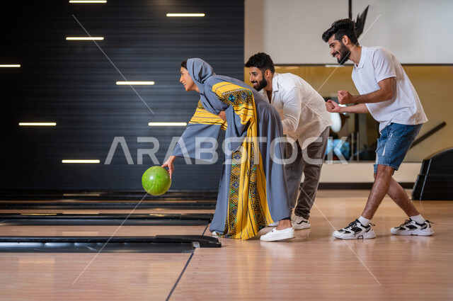 مجموعة من الاصدقاء العرب الخليجيون السعوديون يمارسون لعبه الولينج، مضمار البولينج، شابة تستعد لرمي كرة البولينج، انشطه ترفيهيه رياضية، كره البولينج الترفيهية، انشطه ورياضات شبابية، منافسات وتحديات، فريق من الاصدقاء في ملعب البولينج