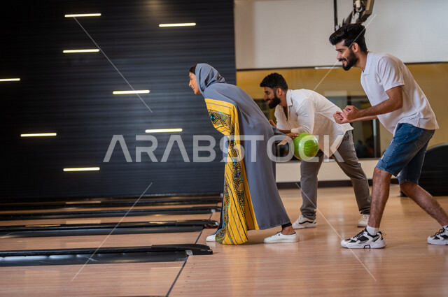 مجموعة من الاصدقاء العرب الخليجيون السعوديون يمارسون لعبه الولينج، مضمار البولينج، شابة تستعد لرمي كرة البولينج، انشطه ترفيهيه رياضية، كره البولينج الترفيهية، انشطه ورياضات شبابية، منافسات وتحديات، فريق من الاصدقاء في ملعب البولينج