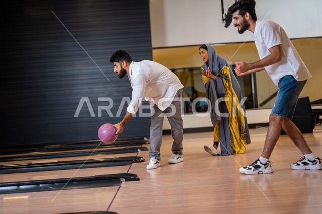 مجموعة من الاصدقاء العرب الخليجيون السعوديون يمارسون لعبه الولينج، مضمار البولينج، شاب يستعد لرمي كرة البولينج، انشطه ترفيهيه رياضية، كره البولينج الترفيهية، انشطه ورياضات شبابية، منافسات وتحديات، فريق من الاصدقاء في ملعب البولينج