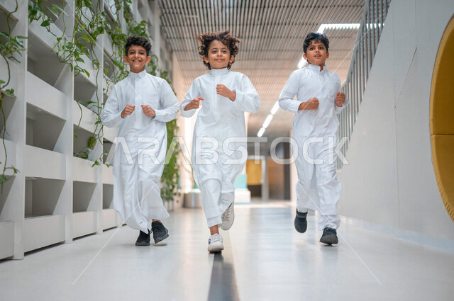 طلاب عرب سعوديون خليجيون يركضون في بهو المدرسه, وقت اللعب والترفيه, الفسحه المدرسيه, ايماءات تدل على السعاده والمرح, الإستعداد للفصل الدراسي الجديد, مدارس أكاديميه في المملكه العربيه السعوديه