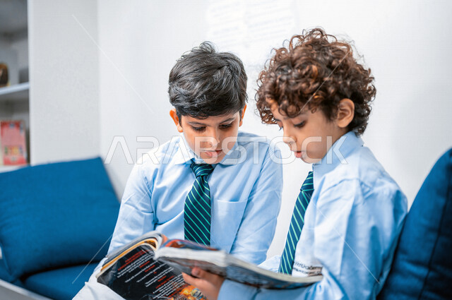 طالبان عربيان سعوديان خليجيان يقومان بقراءة كتاب، مكتبه مدرسيه, الإستعداد للإمتحانات المدرسيه, الدراسه والمذاكره, مفهوم المذاكرة الجماعيه, التعليم والثقافه، التعليم الذاتي, بيئه مدرسيه تعليميه متطوره, مدارس أكاديميه في المملكة العربية السعودية