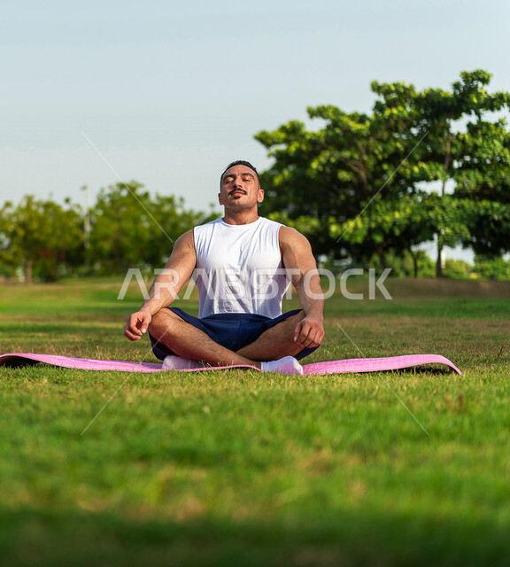 A young Saudi Arabian Gulf youth practicing meditative yoga, practicing sports activity, activities and exercises, meditation and relaxation, sports and physical activity, fitness exercises, healthy lifestyle, fitness and agility