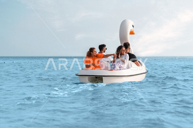 مجموعة من الاصدقاء العرب الخليجيين السعوديين يستمتعون بركوب بدالات مائية على شكل وزة، مراكب فيبر جلاس على بحر جدة، نشاط ركوب القوارب المائية، انشطة ترفيهية، الاستمتاع بالاجازة الصيفية، سياحة وإستجمام، أنشطة صيفية على البحر، العطلة الصيفية