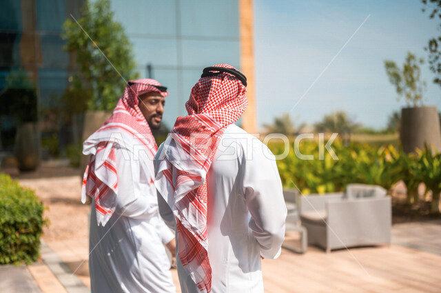 تصوير من الخلف لرجال أعمال عرب سعوديون خليجيون يقومون بالمشي خارج مبنى الشركة، محادثات عامه, نقاشات عمل, زملاء عمل, إنتهاء الدوام، خروج الموظفين، مهن ووظائف سعودية، شركات ومكاتب عربيه سعوديه خليجيه في المملكه العربيه السعوديه