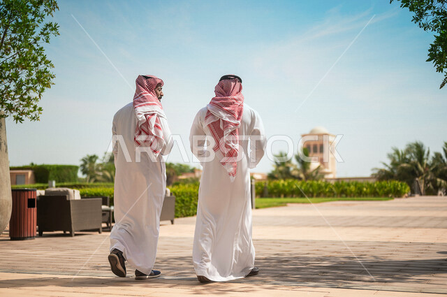 Photography from the back of Saudi Arab Gulf businessmen walking outside the company building, public talks, work discussions, co-workers, end of work, employee exit, Saudi professions and jobs, Saudi Arabian Gulf companies and offices in the Kingdom of S
