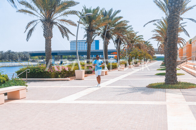 A Saudi Arabian Gulf man practicing morning sports on the Jeddah Corniche, running on the Jeddah Corniche Tourist Walk, Jeddah Waterfront, recreational tourist places in Saudi Arabia, recreation and entertainment, maintaining fitness and good health, recr