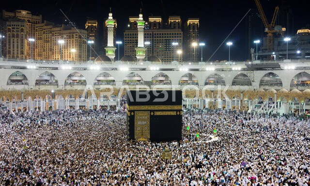 Pilgrims circumambulating the Holy Kaaba, the Holy Mosque in Mecca, Saudi Arabia at night, performing Hajj and Umrah, worshiping and getting closer to God, Islamic religious landmarks, Hajj season