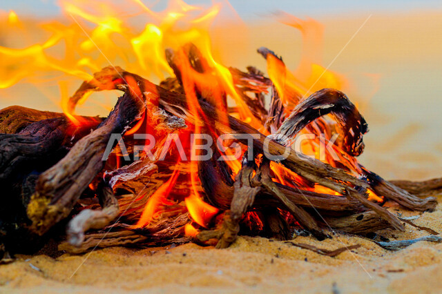 النيران المشتعلة في الحطب نهارا ، اللهب الأحمر المشتعل في رحلة تخييم بالصحراء ، التخييم في صحراء المملكة العربية السعوديه، البر و التخييم, التدفئه بإشعال الحطب