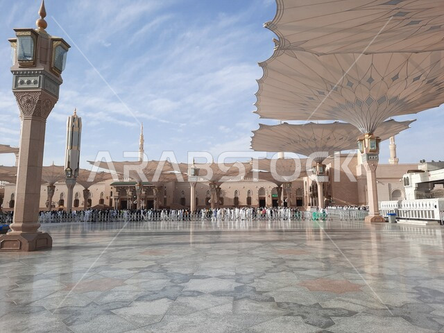 ساحة المسجد النبوي الشريف في المدينة المنورة بالمملكة العربية السعودية، العبادة والتقرب الى الله، الحرم النبوي الشريف، أماكن إسلامية مقدسة، المسلمون يمشون في المجمع الخارجي للمسجد النبوي في المدينة المنورة، المظلات الإلكترونية