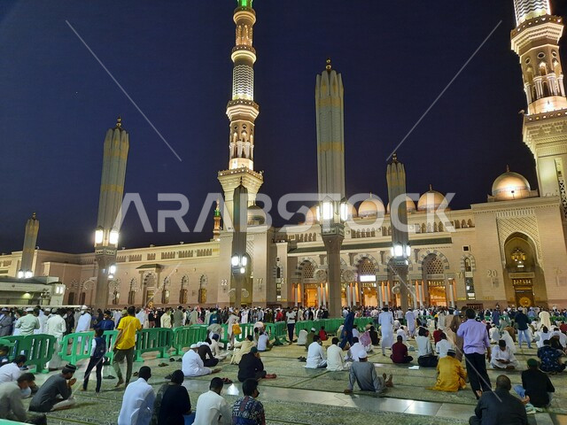 مجموعة من المصلين في ساحة المسجد النبوي الشريف في المدينة المنورة بالمملكة العربية السعودية في وضع الليل، العبادة والتقرب الى الله، الحرم النبوي الشريف، أماكن إسلامية مقدسة، المجمع الخارجي للمسجد النبوي في المدينة المنورة، إسلاميات وعبادة
