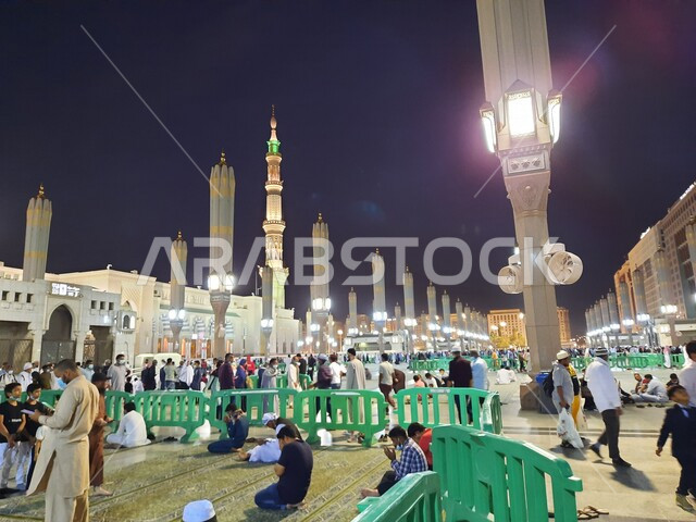مجموعة من المصلين في ساحة المسجد النبوي الشريف في المدينة المنورة بالمملكة العربية السعودية في وضع الليل، العبادة والتقرب الى الله، الحرم النبوي الشريف، أماكن إسلامية مقدسة، المجمع الخارجي للمسجد النبوي في المدينة المنورة، إسلاميات وعبادة