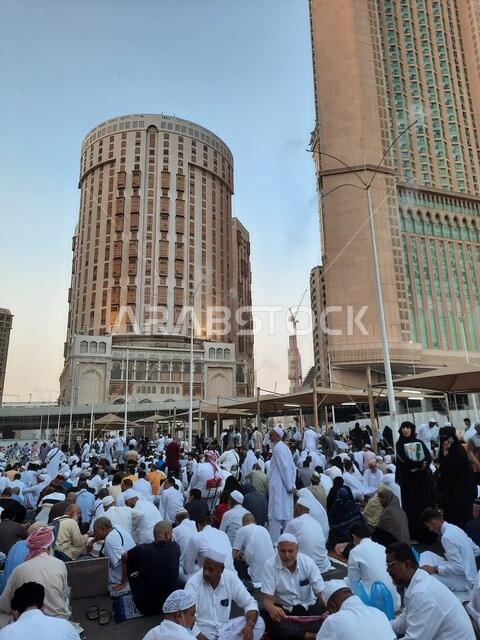  مجموعة من زوار بيت الله الحرام يجلسون في شوارع مكة المكرمة بالمملكة العربية السعودية، الشوارع والطرقات، الحجاج والمعتمرين، ابراج وفنادق مكة، معالم السعودية، السياحة في السعودية