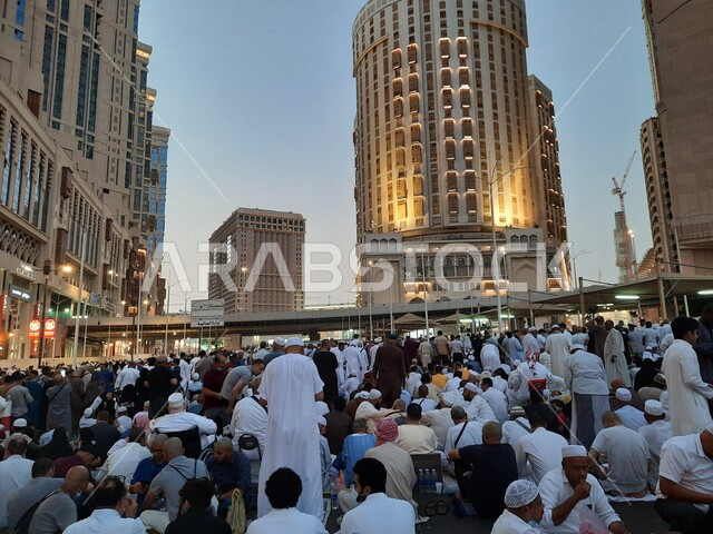  مجموعة من زوار بيت الله الحرام يجلسون في شوارع مكة المكرمة بالمملكة العربية السعودية، الشوارع والطرقات، الحجاج والمعتمرين، ابراج وفنادق مكة، معالم السعودية، السياحة في السعودية