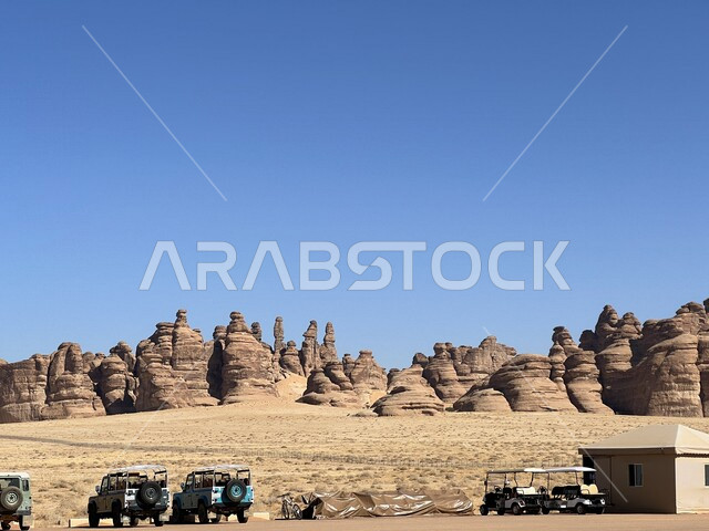 مجموعة من السياح في زيارة لمحافظة العلا بالمملكة العربية السعودية، التكوينات الصخرية الطبيعية في مدائن صالح، الطبيعة الصحراوية، الجبال والتشكيلات الصخرية في محافظة العلا، أماكن سياحية، معالم تاريخية أثرية قديمة