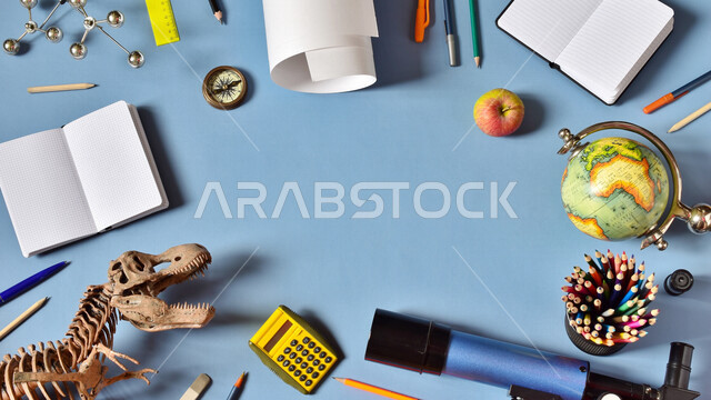 مفهوم العودة إلى المدارس ، مجموعة من الأقلام والكتب ومجسم الكرة الأرضية على الطاولة ، مفهوم الجغرافيا وتاريخ العصور القديمة 