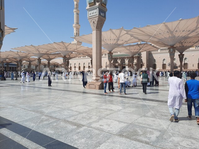 ساحة المسجد النبوي الشريف في المدينة المنورة بالمملكة العربية السعودية، العبادة والتقرب الى الله، الحرم النبوي الشريف، أماكن إسلامية مقدسة، تجمع المسلمون في المجمع الخارجي للمسجد النبوي في المدينة المنورة، المظلات الإلكترونية، معالم دينية إسلامية