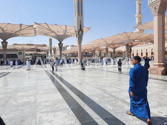 ساحة المسجد النبوي الشريف في المدينة المنورة بالمملكة العربية السعودية، العبادة والتقرب الى الله، الحرم النبوي الشريف، أماكن إسلامية مقدسة، تجمع المسلمون في المجمع الخارجي للمسجد النبوي في المدينة المنورة، المظلات الإلكترونية، معالم دينية إسلامية