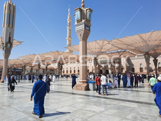 The square of the Prophet’s Mosque in Medina, Saudi Arabia, worship and getting closer to God, the Prophet’s Mosque, holy Islamic places, Muslims gathering in the outer complex of the Prophet’s Mosque in Medina, electronic umbrellas, Islamic religious lan