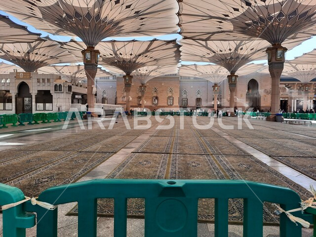 ساحة المسجد النبوي الشريف في المدينة المنورة بالمملكة العربية السعودية، العبادة والتقرب الى الله، الحرم النبوي الشريف، أماكن إسلامية مقدسة، المسلمون يمشون في المجمع الخارجي للمسجد النبوي في المدينة المنورة، المظلات الإلكترونية