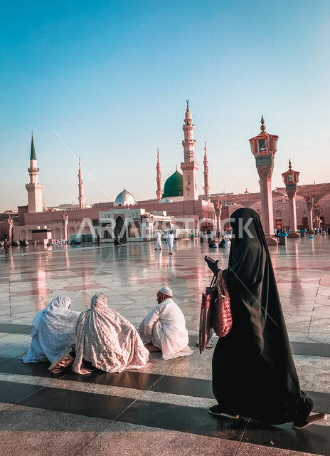 مجموعة من المصليين يجلسون في ساحة المسجد النبوي الشريف في المدينة المنورة بالمملكة العربية السعودية، الحرم النبوي الشريف، المسجد النبوي الشريف، العبادة والتقرب إلى الله، المعالم الدينية بالسعودي