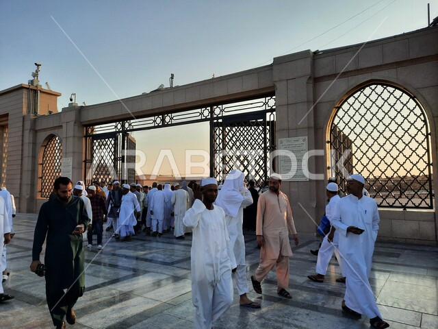 مجموعة من المسلمين يدخلون مقبرة البقيع الإسلامية في المدينة المنورة بالمملكة العربية السعودية، مقبرة بقيع الغرقد، زيارة قبور أئمة البقيع، اماكن اسلامية مقدسة، المعالم الدينية بالسعودية، السياحة في السعودية