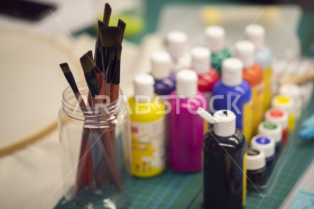 مجموعة من عبوات الألوان المختلفة، فرش الطلاء مختلفة الاحجام، ادوات الرسم بالألوان المائية، فنون جميلة، فن تشكيلي