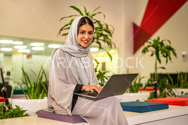 صوره مقربه لإمرأة عربية سعودية خليجيه تستخدم جهاز الحاسوب المحمول, طالبه جامعيه، أبحاث ودراسات علميه, إجراء مكالمة فيديو, تواصل إجتماعي، إجتماع عبر الإنترنت، التسويق الإلكتروني، تصفح الإنترنت, دردشة ومحادثات, جامعات أكاديميه متطوره في السعوديه