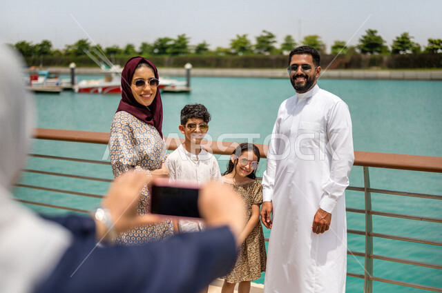 عائله عربيه سعوديه خليجيه في ممشى كورنيش جده, إلتقاط صور تذكاريه عبر الهاتف المحمول, لحظات جميله, أنشطه عائليه ترفيهيه, التنزه في مارينا جده, عطله صيفيه, السياحه في المملكه العربيه السعوديه